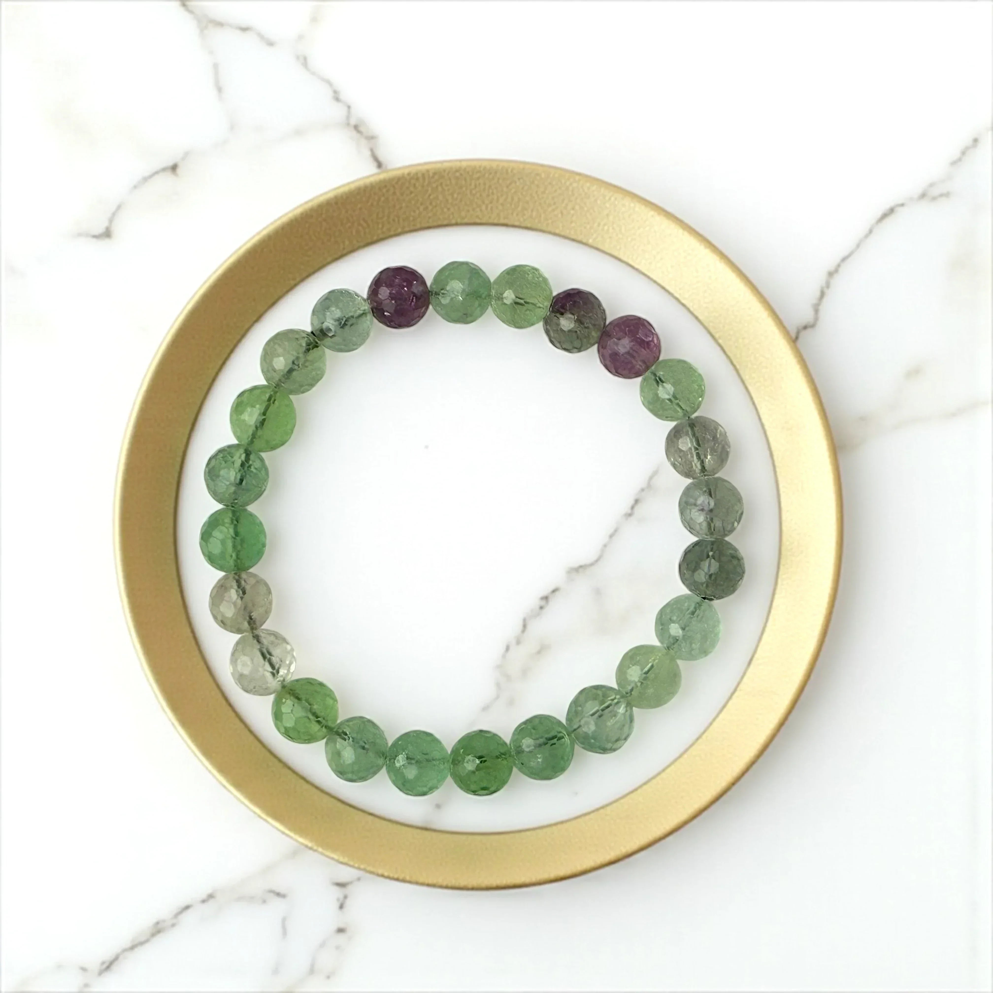 latatva multi fluorite beaded bracelet with green and purple stones on a marble surface
