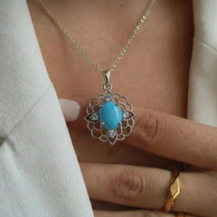 Turquoise pendant necklace on a person wearing a white jacket, with 'Turquoise Elegance' text above.