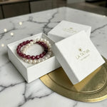 LA TATVA ruby and pearl beaded bracelet stack in a white gift box on a marble surface.
